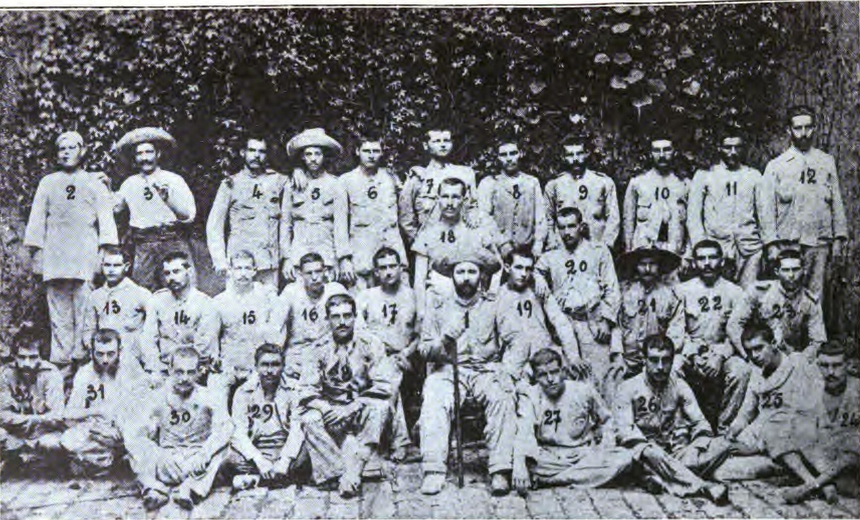 Fotografía antigua de un grupo de soldados con uniforme de rayas y sombreros de paja
